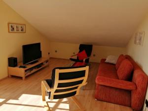 ein Wohnzimmer mit einem Sofa und einem TV in der Unterkunft Ferienhaus Scholz in Rieden