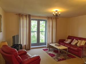 uma sala de estar com um sofá vermelho e uma televisão em The Avenue em Leamington Spa