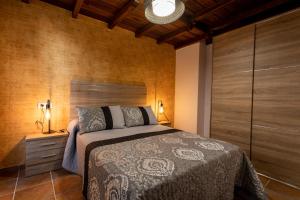 a bedroom with a bed and a wooden wall at Los Nidos De Isabel in Mogarraz