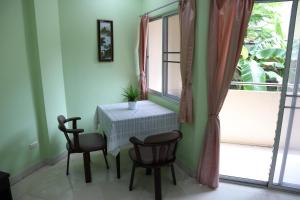 a table and chairs in a room with a window at แสนสุขอพาร์ทเมนท์ in Bangsaen