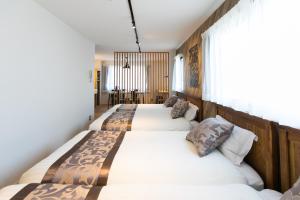 een slaapkamer met 3 bedden en een raam bij wisdom minosima inn in Fukuoka