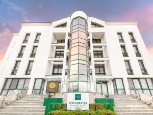 a white building with stairs in front of it at Alex&George Boutique Hotel in Cluj-Napoca