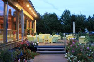 a deck with chairs and tables on a building at Airporthotel Salzburg - Hotel am Salzburg Airport in Salzburg