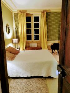 una camera con un letto bianco e una finestra di Les chambres d'hôtes du Manoir de Roz-Maria a Quintin