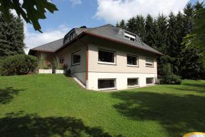a house on a grassy yard with trees at Eifel Relax in Hillesheim