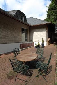 a wooden table and chairs on a brick patio at Eifel Relax in Hillesheim