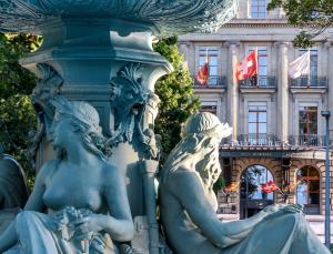 a statue of two women in front of a building at Hôtel Métropole Genève in Geneva