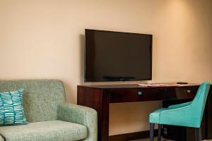 a living room with a tv and a chair at Paxton Hotel in Port Elizabeth