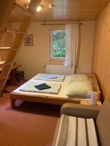 ein großes Bett in einem Zimmer mit Fenster in der Unterkunft Kamenný Mlýn in Strážné