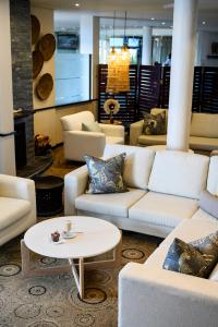 a living room with white couches and a table at Paxton Hotel in Port Elizabeth