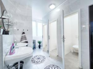 a white bathroom with a sink and a toilet at Pension Amanda in Berlin +47 photos
