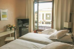 Una cama o camas en una habitación de Hotel Les Arcades