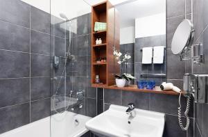 een badkamer met een wastafel, een douche en een spiegel bij Hotel City Oase Lb in Ludwigsburg