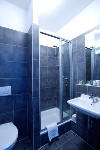 La salle de bains est pourvue d'une douche, d'un lavabo et de toilettes. dans l'établissement Hotel City Oase Lb, à Ludwigsbourg