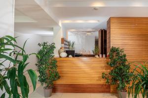 a lobby with potted plants on the wall at Hotel Martini in Lignano Sabbiadoro