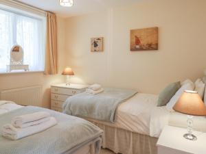 a bedroom with two beds and a window at Willow Barn in Wincanton