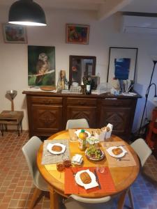 Saint-Sulpice-de-Faleyrens的住宿－Au Vélo dans l'Arbre，一张木桌,上面放着食物盘