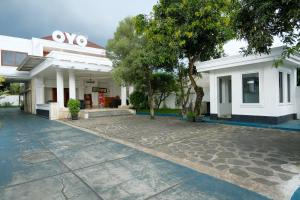 a white house with a driveway in front of it at OYO Capital O 514 Omah Pari Boutique Hotel in Yogyakarta