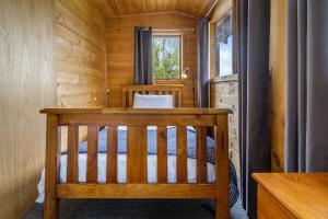 Cabaña de madera con cama en una habitación en Mole Creek Cabins, en Mole Creek