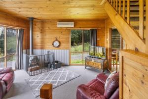 a living room filled with furniture and a fire place at Mole Creek Cabins in Mole Creek