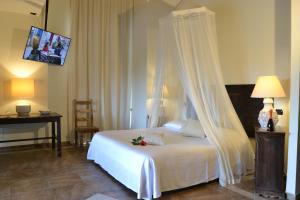 a bedroom with a white bed with a canopy at Hotel Costa dei Fiori in Santa Margherita di Pula