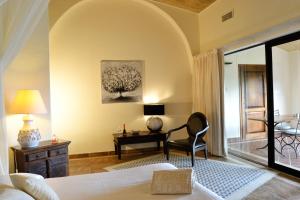 a bedroom with a bed and a desk and a chair at Hotel Costa dei Fiori in Santa Margherita di Pula