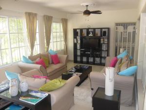 a living room with two couches and a tv at Villa Los Almendros - 2 pools and private tennis court in Baní