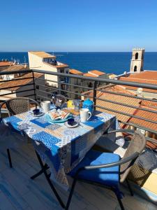 a table on a balcony with a meal on it at Dolce Estate Cefalù in Cefalù