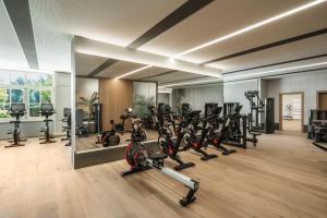 ein Fitnessstudio mit einem Haufen Laufbänder und Heimtrainern in der Unterkunft Interalpen-Hotel Tyrol in Buchen