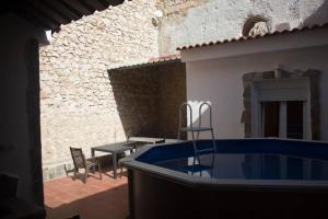 a patio with a hot tub and a table and chairs at El Descansito del Rey in El Chorro