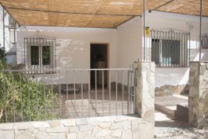 ein weißes Haus mit einem Zaun und einem Tor in der Unterkunft El Descansito del Rey in El Chorro
