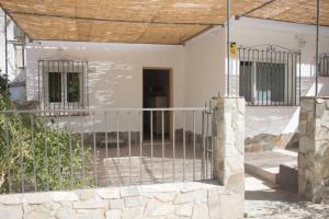 a white house with a fence and a gate at El Descansito del Rey in El Chorro