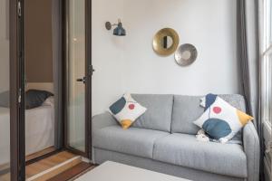 uma sala de estar com um sofá cinzento e um espelho em Hostalin Barcelona Gran Via em Barcelona