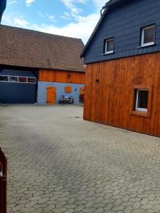 a large wooden building with a parking lot next to it at Zimmervermietung KaSa in Groß Lafferde
