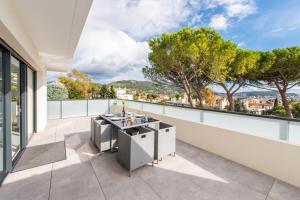 een patio met een tafel en stoelen op een balkon bij Elegance in Nice