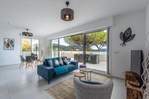 een woonkamer met een blauwe bank en een aantal stoelen bij Elegance in Nice