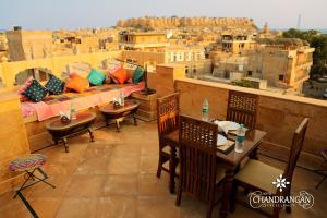 a balcony with tables and chairs and a view of a city at Treebo Trend Chandrangan Excellency 1 Km From Jaisalmer Fort in Jaisalmer