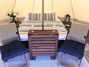 sypialnia z łóżkiem z 2 krzesłami i komodą w obiekcie Vesterålen Beach Glamping w mieście Bø i Vesterålen