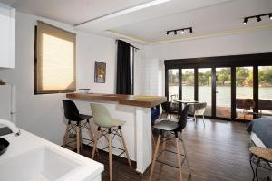 uma cozinha e sala de estar com um balcão e cadeiras em Beach House Belgrade em Belgrado