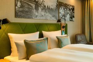 
a hotel room with two beds and a painting on the wall at Motel One Salzburg-Süd in Salzburg
