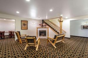 a living room with two chairs and a staircase at Inn at Lander, Travelodge by Wyndham in Lander