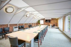 uma longa sala de conferências com mesas e cadeiras longas em Palads Hotel em Viborg