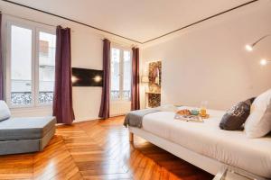 ein Schlafzimmer mit einem großen Bett und einem großen Fenster in der Unterkunft Luxueux Duplex 6 - 8pers - Full Equipped - République in Paris