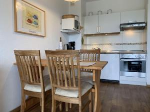 a kitchen with a wooden dining table and chairs at Haus-am-Deich-Wohnung-2 in Dahme