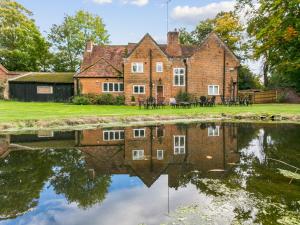 una casa vieja con su reflejo en el agua en Historical Cottage Escape BIG en Burnham