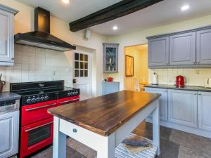 a kitchen with a red stove and white cabinets at Historically Charming Home with Large Garden- Pass the Keys in Burnham
