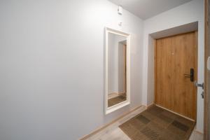 a hallway with a wooden door and a mirror at Wonderful Apartment in the City Center in Šiauliai