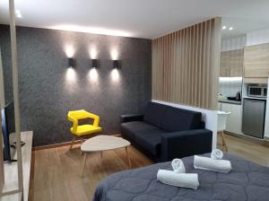 - un salon avec un lit et une chaise jaune dans l'établissement VH Executive Suites, à Thessalonique