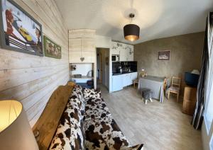 a living room with a bed with cows on it at Boost Your Immo Le Villaret Risoul 377 in Risoul