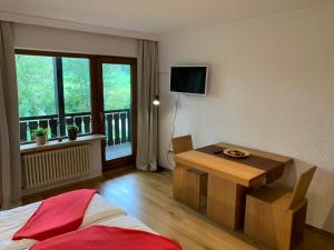 a room with a bed and a table and a window at Kuckucksnest Jostal in Titisee-Neustadt